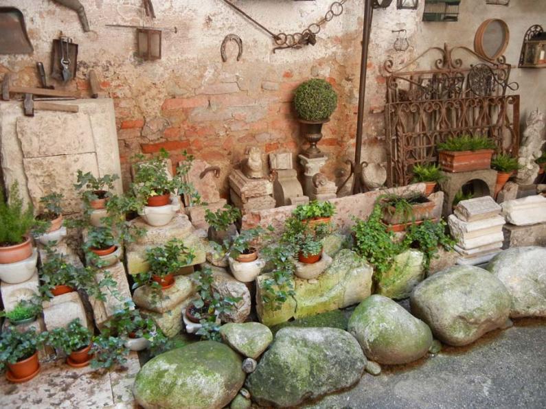 Pietre antiche rotte ammassate e piantine di edere.